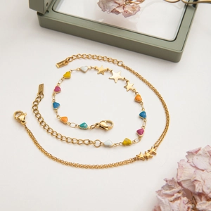 Detail of star and colorful enamel heart charms on a gold stainless steel chain bracelet