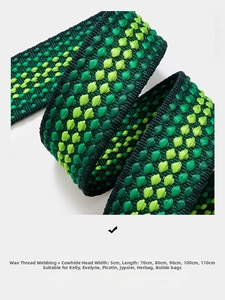Detailed macro view of 5cm wide green and yellow woven strap with leather ends