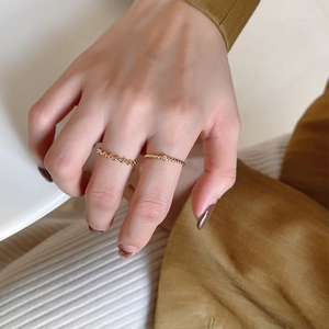 Minimalist 925 silver beaded rings in gold finish worn by model on white background