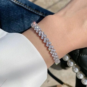 Elegante bracciale a catena intrecciata in argento con zirconi lucidi al polso di una modella