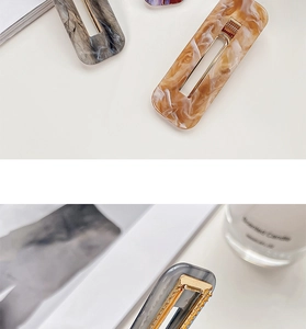 Macro shot of rectangular acrylic hair clips in marble, purple, and amber textures