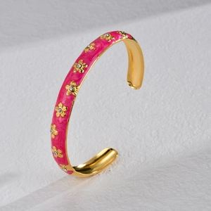 Pink enamel flower open bangle in gold finish with small crystals on white texture