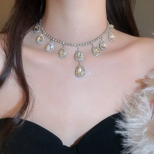 Close-up of elegant silver drop necklace with sparkling crystals on model's neck