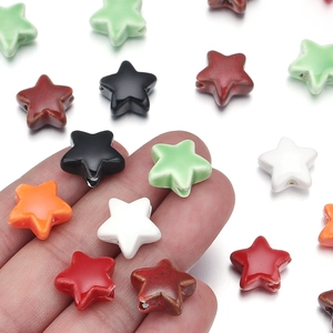 Hand holding colorful star ceramic beads for DIY jewelry making and handmade accessories