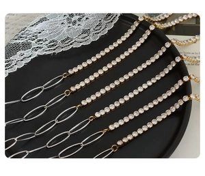 Detail of gold and silver chain necklace with inlaid zircon and oval textured links
