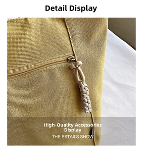Detail shot of yellow canvas bag showing heavy-duty zipper and braided tassel puller