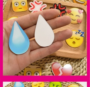 Macro view of cute emoji acrylic badges featuring water drops and sleepy ZZZ motifs