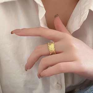 French style 925 silver wide gold ring with irregular lava texture worn by a model