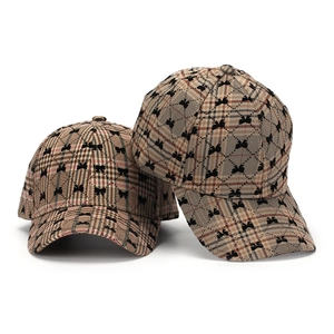 Khaki plaid baseball cap with black bow print, front and side view on white background