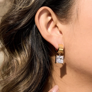 Detail of 18K gold stainless steel earrings featuring a large square sparkling zircon stone