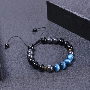 Détail des perles de 10mm en oeil de tigre bleu et hématite sur bracelet tressé ajustable