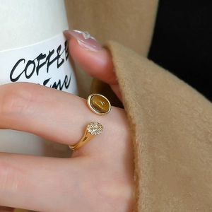 Macro shot of an oval tiger eye stone ring with crossover design and diamond accents