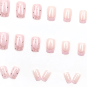 Short french nude pink press-on nails with bow design and pearlescent shimmer finish