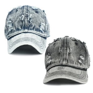 Close-up of washed denim baseball caps featuring vintage distressed holes and frayed edges
