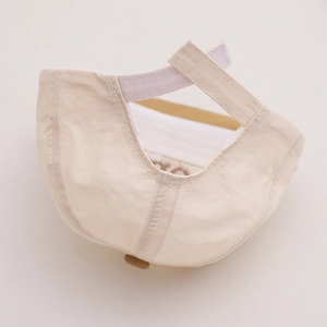 Détail de la sangle Velcro et de la bande anti-sueur de la casquette beige pour enfants