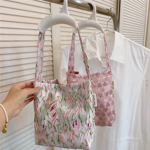 Detail of floral embroidery and heart jacquard texture on pink fabric tote bags