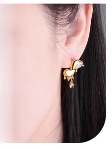 Close-up of giraffe-shaped gold earring with heart and square-cut zircon stones