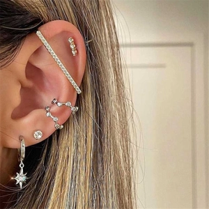 Detail of silver S925 earrings set with star pendants and sparkling diamond accents
