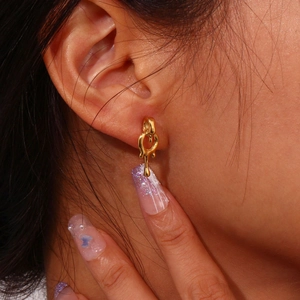 Close-up of minimalist gold 18K plated lava drop earrings on a model ear lobe