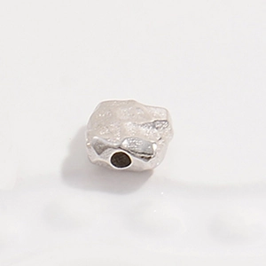 Macro view of a single square hammered texture S925 silver bead for jewelry making
