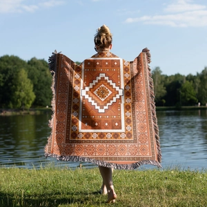 Detail view of Bohemian woven blanket with fringe and tribal geometric pattern outdoors