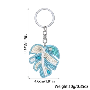 Detail showing dimensions of beaded monstera leaf keychain in turquoise and white