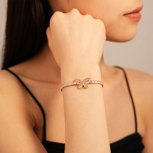 Elegante bracciale a farfalla dorata con zirconi sul polso di una modella, lusso