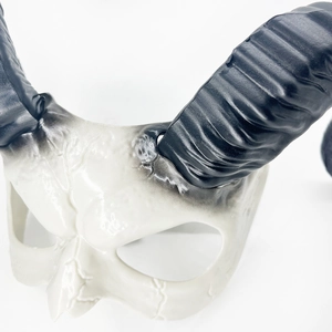 Gros plan sur un masque de crâne réaliste avec des cornes en spirale pour Halloween