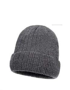 Detail of dark gray ribbed knit beanie with thick texture and leather brand patch