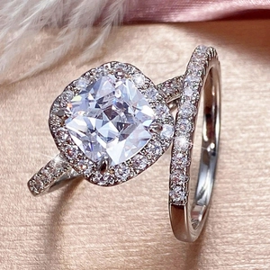 Elegant cushion-cut halo wedding ring set with silver platinum finish on silk backdrop