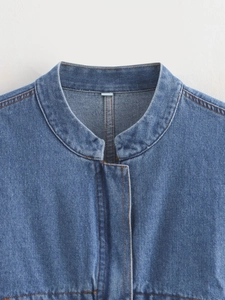 Close-up of blue denim jacket with contrast orange stitching and vintage wash details