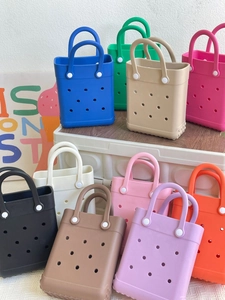 Colorful waterproof EVA beach bags in multiple vibrant colors stacked against a white wall