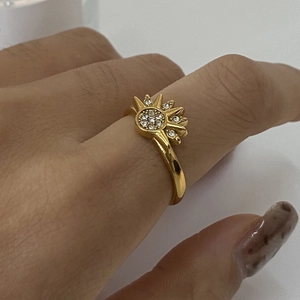 Adjustable golden stainless steel ring featuring a sunburst design with sparkling zircon stones