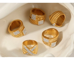 Macro shot of gold plated titanium rings with diamond pavé and woven texture detail
