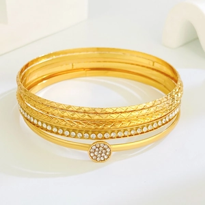 Detailed macro view of 6-piece gold bangle set with sparkling cubic zirconia accents