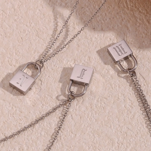 Macro shot of silver stainless steel lock pendant necklaces with Gothic letter engravings