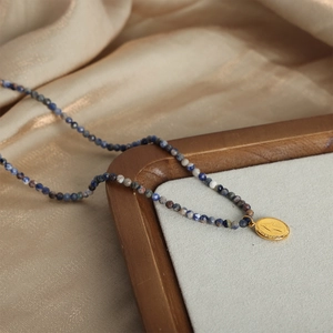 Vintage beaded necklace with blue natural stones and gold embossed portrait pendant