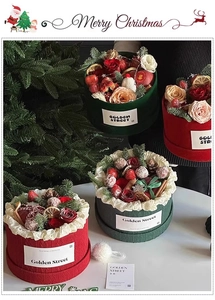 Detail of Christmas flower box with red roses, pine cones, and cinnamon sticks decoration