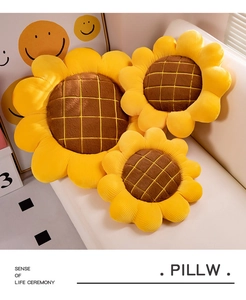 Close-up of three plush sunflower cushions in different sizes on a cozy beige sofa