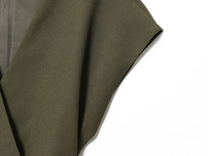Macro shot showing olive green woven fabric texture and lining of the v-neck top