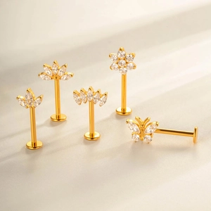 G23 titanium labret studs featuring gold butterfly and flower zircon designs