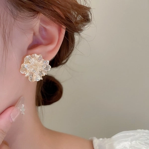 Elegant 3D resin flower stud earrings with crystals and gold plating on a female model