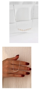 Detail of 925 sterling silver necklace featuring seven white pearls in a smile design