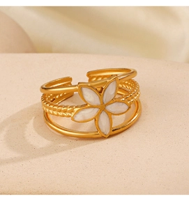 Detail of 18K gold plated triple-layer ring featuring a white floral enamel charm