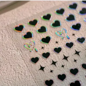 Détail macro de stickers à ongles cœurs noirs rétro avec contours laser colorés