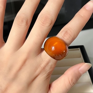 Minimalist vintage orange resin ring with bold amber-style dome on person hand