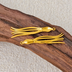 Macro detail of two golden octopus charms made of 304 stainless steel for DIY jewelry