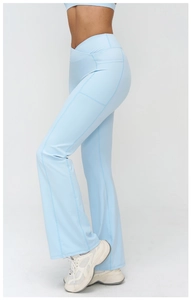Détail du pantalon de yoga évasé bleu clair à taille haute avec poches et ceinture croisée
