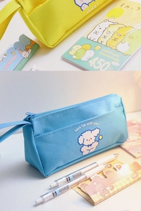 Detail of blue and yellow canvas pencil cases with cartoon dog embroidery and zippers