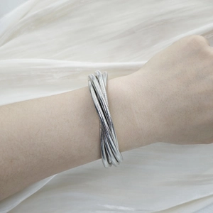 Macro detail of silver multi-layer coiled spring bracelet with spiral metal texture